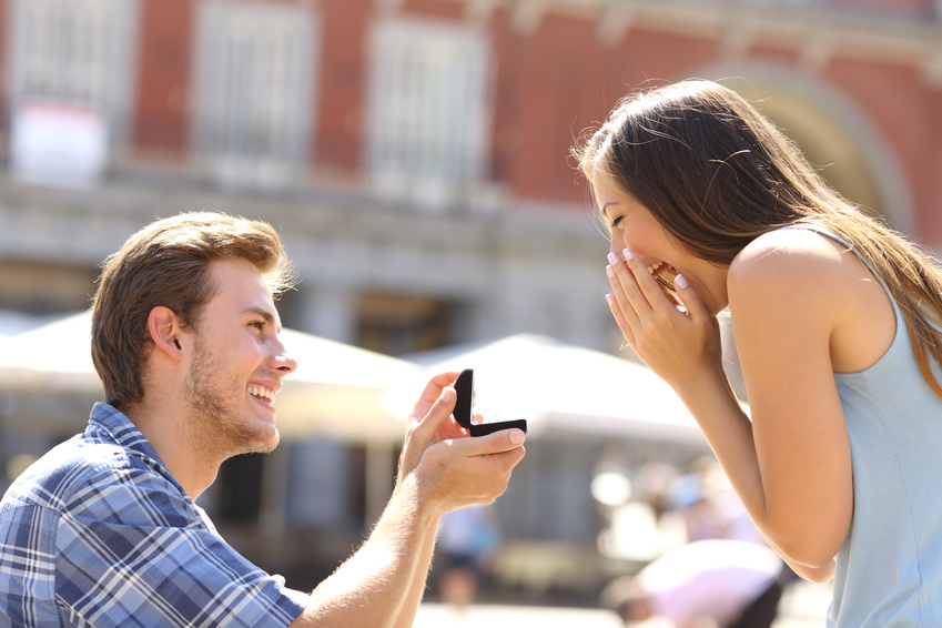 Proposal in the street with a man asking marry to his happy girlfriend