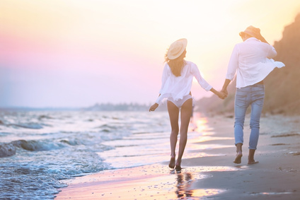 Young happy couple walking on seashore