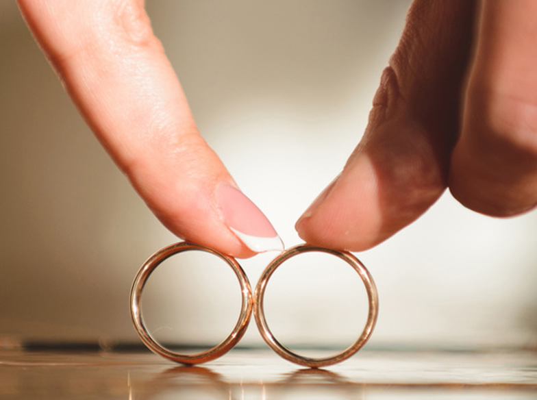 couple touching rings by fingers