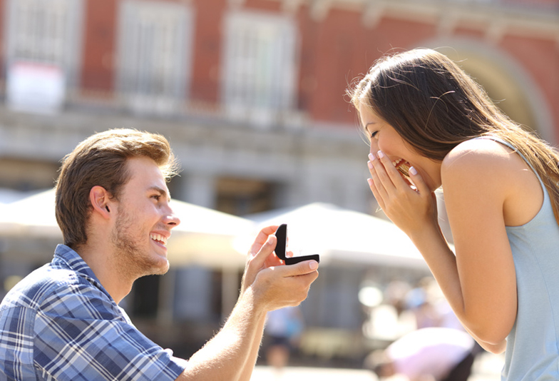 Proposal in the street with a man asking marry to his happy girlfriend