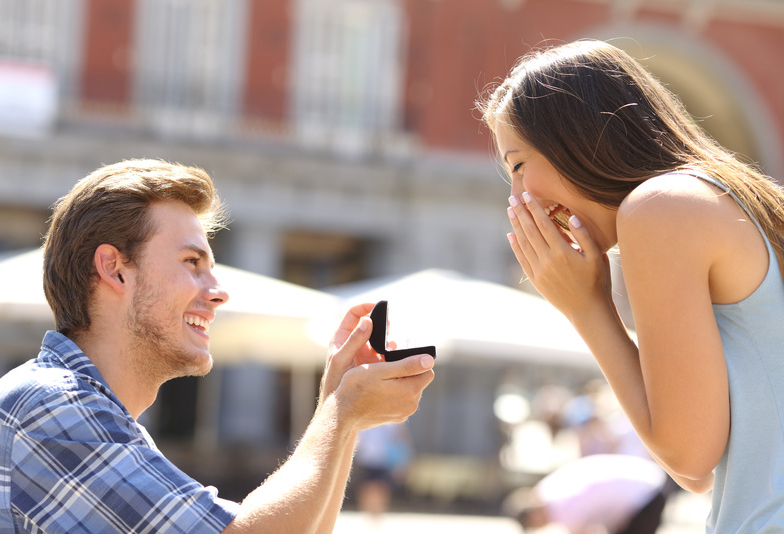 Proposal in the street with a man asking marry to his happy girlfriend