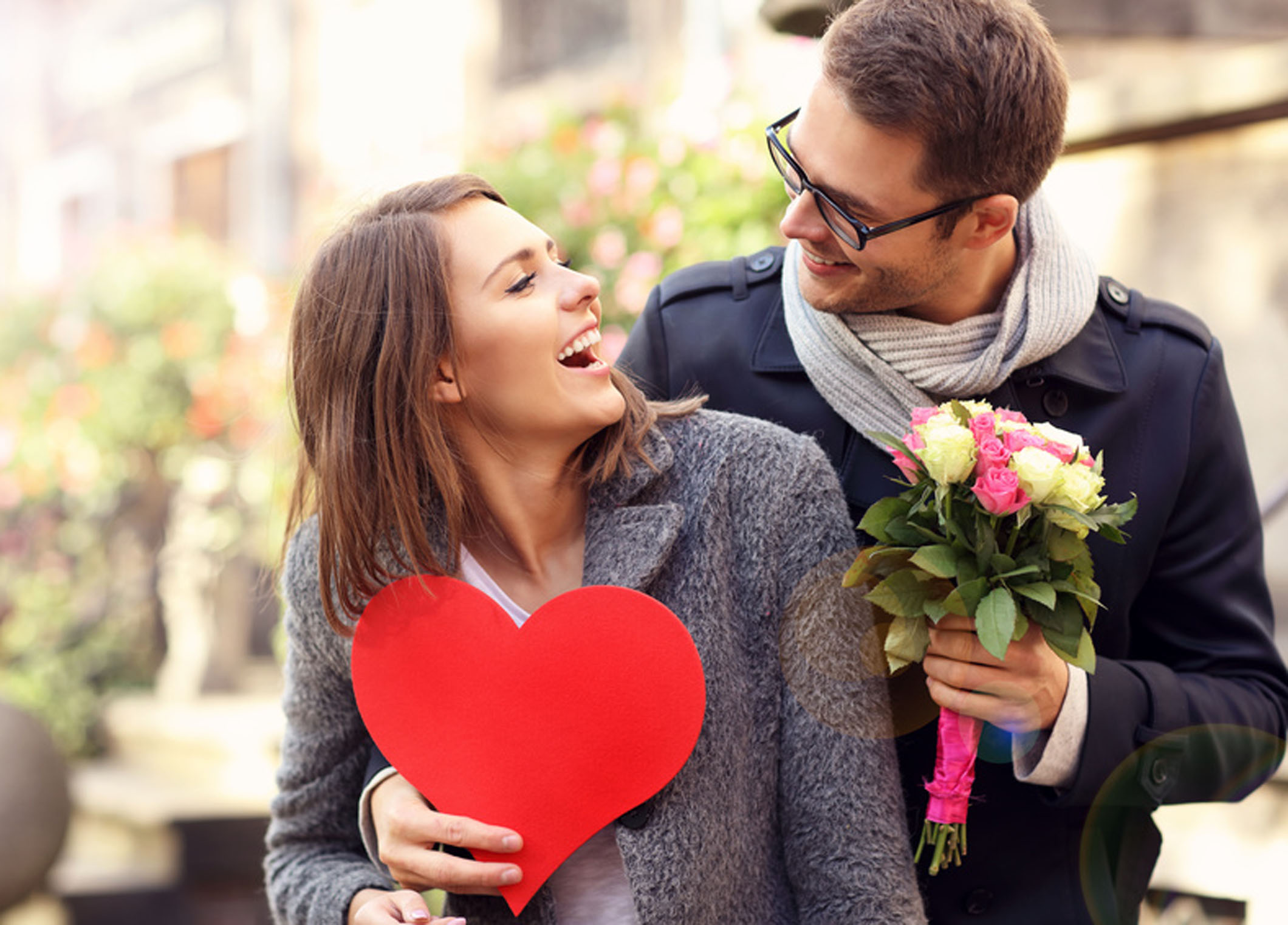 Picture of young man surprising woman with flowers and heart