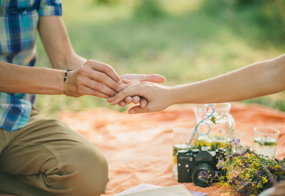 engagement ring proposal hands close up in picnic