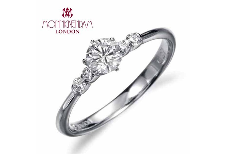 メインとなるダイヤモンドの両サイドに2石ずつ小さなダイヤが留められた愛らしいデザイン