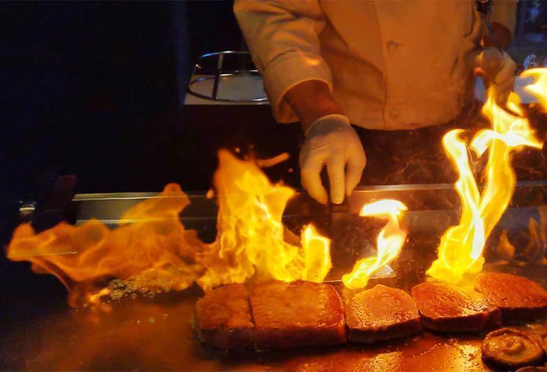 鉄板の上でシェフが牛肉を焼く