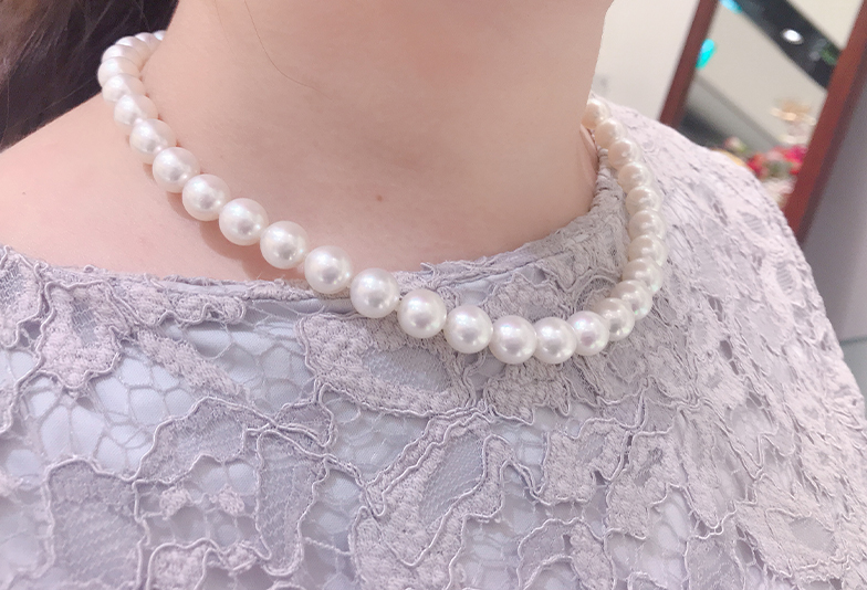 福井市のショップで真珠ネックレスを試着した女性