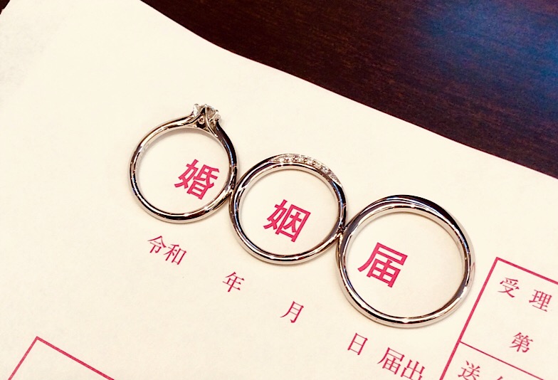 婚姻届に置かれた婚約指輪と結婚指輪